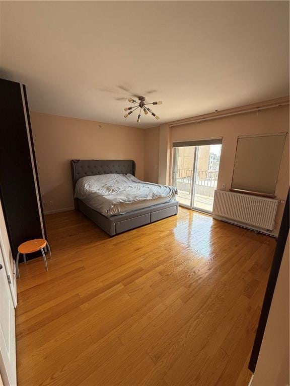2964 Brighton 6th St Unit 4B, Brooklyn, NY 11235 - bedroom with access to exterior, radiator, and light wood-style floors