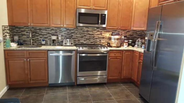 5463 Arthur Kill Rd, Staten Island, NY 10307 - kitchen with stainless steel appliances, decorative backsplash, and dark tile patterned floors