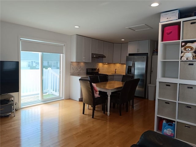 268 Nelson Ave, Staten Island, NY 10308 - kitchen featuring stainless steel appliances, under cabinet range hood, light wood-type flooring, light countertops, and backsplash