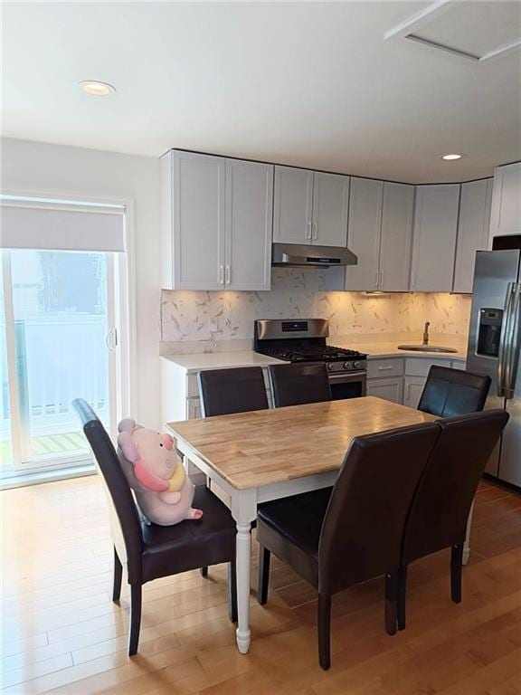 268 Nelson Ave, Staten Island, NY 10308 - kitchen with appliances with stainless steel finishes, gray cabinets, light wood-type flooring, under cabinet range hood, and light countertops