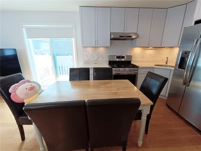 268 Nelson Ave, Staten Island, NY 10308 - kitchen with stainless steel appliances, under cabinet range hood, decorative backsplash, and light countertops
