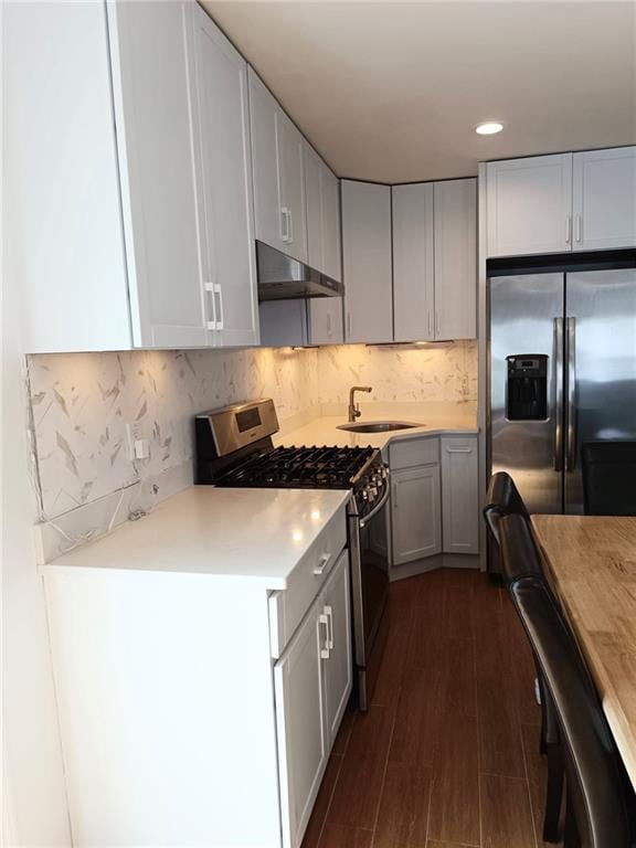 268 Nelson Ave, Staten Island, NY 10308 - kitchen featuring stainless steel appliances, under cabinet range hood, light countertops, dark wood-style floors, and backsplash