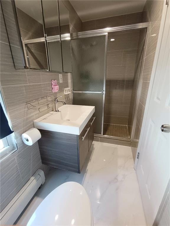 268 Nelson Ave, Staten Island, NY 10308 - bathroom featuring vanity, a shower stall, tile walls, marble look tile flooring, and a baseboard heating unit