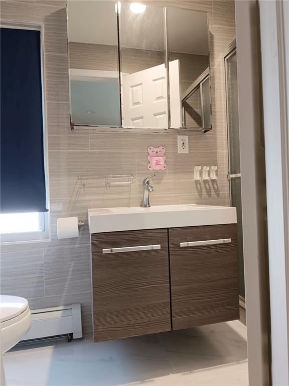 268 Nelson Ave, Staten Island, NY 10308 - bathroom featuring a baseboard radiator, vanity, tile walls, and a shower with shower door