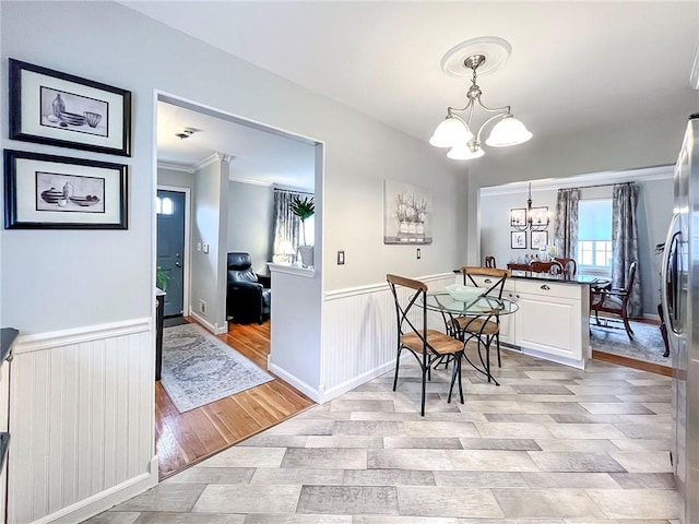 21 Stroud Ave, Staten Island, NY 10312 - dining room featuring a chandelier, light wood-style flooring, a wainscoted wall, and ornamental molding