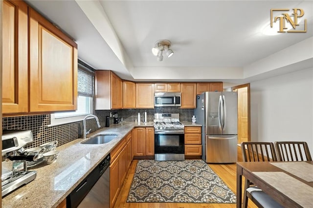 7 Kunath Ave, Staten Island, NY 10309 - kitchen featuring appliances with stainless steel finishes, tasteful backsplash, light stone counters, light wood-style flooring, and a tray ceiling