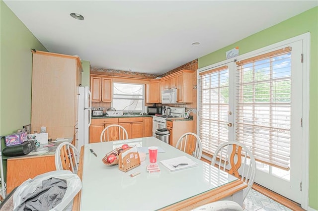 2286 Brigham St Unit 1E, Brooklyn, NY 11229 - kitchen featuring white appliances, plenty of natural light, light brown cabinets, and light wood-style floors