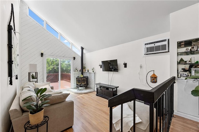 324 Norway Ave, Staten Island, NY 10305 - living room featuring a wood stove, wood finished floors, a wall mounted AC, and high vaulted ceiling