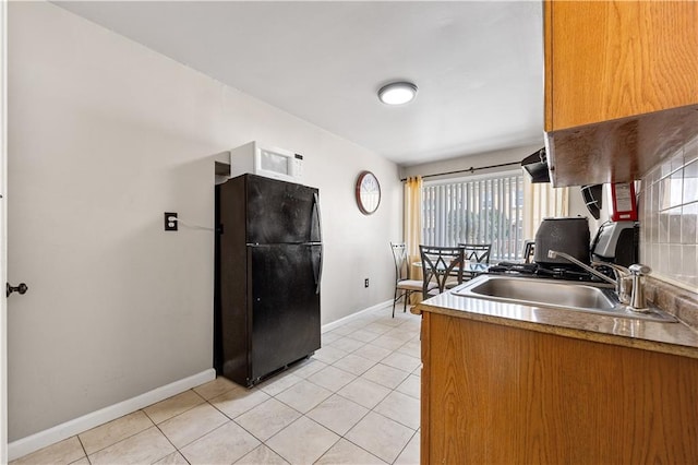 324 Norway Ave, Staten Island, NY 10305 - kitchen featuring freestanding refrigerator, light tile patterned floors, white microwave, and brown cabinetry