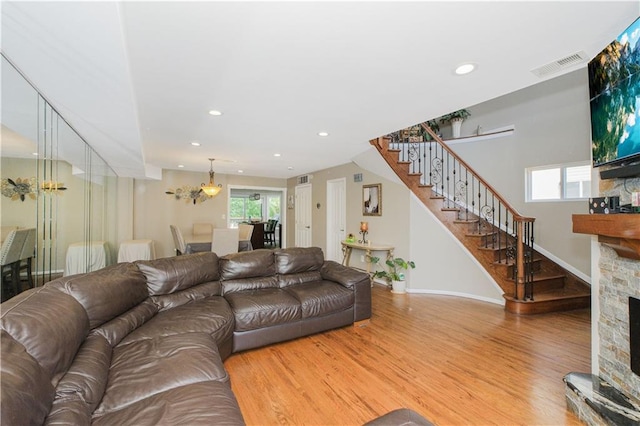 37 Quail Ln, Staten Island, NY 10309 - living area featuring a chandelier, stairway, wood finished floors, a stone fireplace, and plenty of natural light