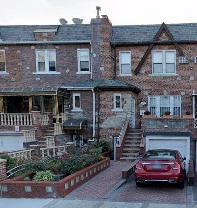 743 E 49th St, Brooklyn, NY 11203 - townhome / multi-family property with brick siding, stairs, an attached garage, driveway, and a chimney