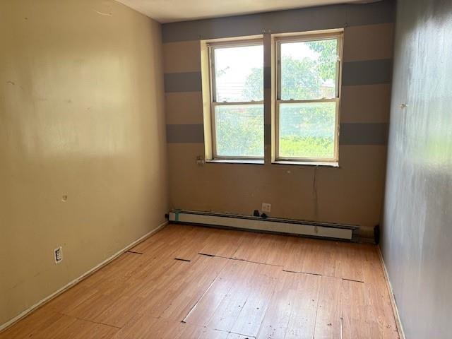 894 New Lots Ave, Brooklyn, NY 11208 - unfurnished room with a baseboard radiator and wood finished floors