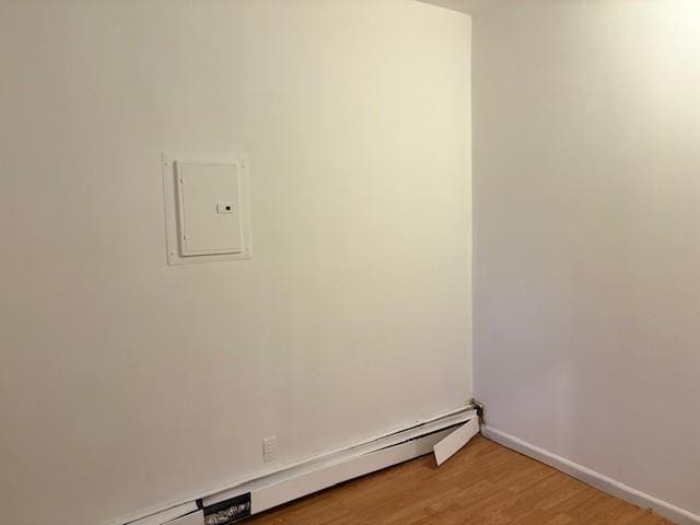 894 New Lots Ave, Brooklyn, NY 11208 - laundry area featuring a baseboard heating unit, light wood-type flooring, and electric panel