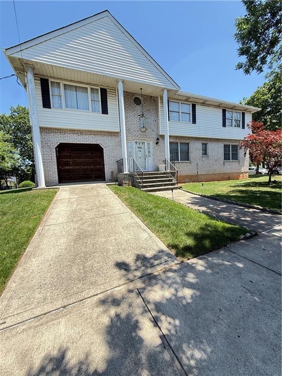 669 Bloomingdale Rd, Staten Island, NY 10309 - view of front of house featuring driveway, brick siding, a garage, and a front lawn