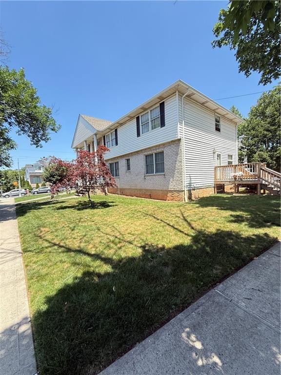 669 Bloomingdale Rd, Staten Island, NY 10309 - view of property exterior with a deck, a lawn, and brick siding