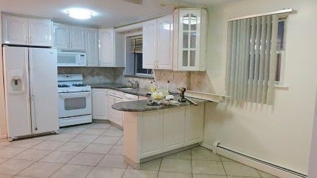 1247 E 69th St, Brooklyn, NY 11234 - kitchen with white appliances, a peninsula, baseboard heating, glass insert cabinets, and light tile patterned floors