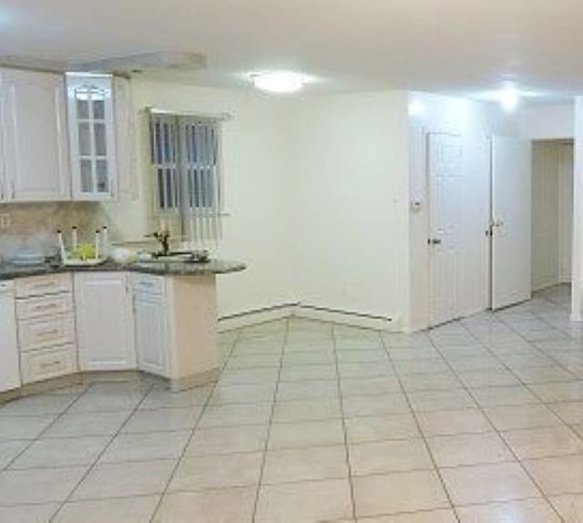 1247 E 69th St, Brooklyn, NY 11234 - kitchen with dark countertops and light tile patterned floors