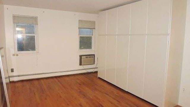 1247 E 69th St, Brooklyn, NY 11234 - unfurnished bedroom with baseboard heating and wood finished floors