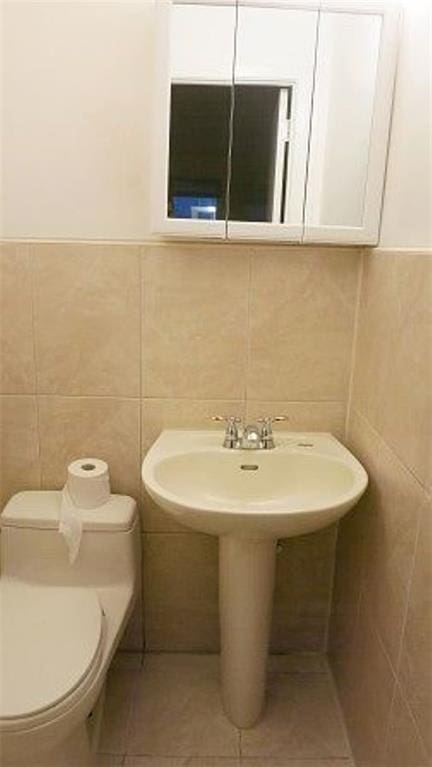 1247 E 69th St, Brooklyn, NY 11234 - half bath with tile walls, tile patterned floors, and wainscoting