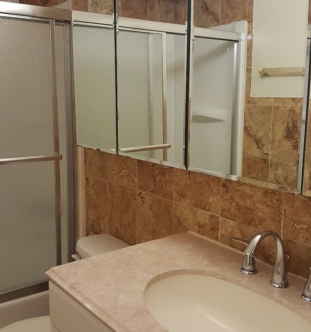 1247 E 69th St, Brooklyn, NY 11234 - bathroom with tile walls, vanity, and combined bath / shower with glass door