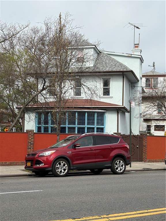 2339 80th St, Brooklyn, NY 11214 - view of front of property featuring stucco siding and roof with shingles