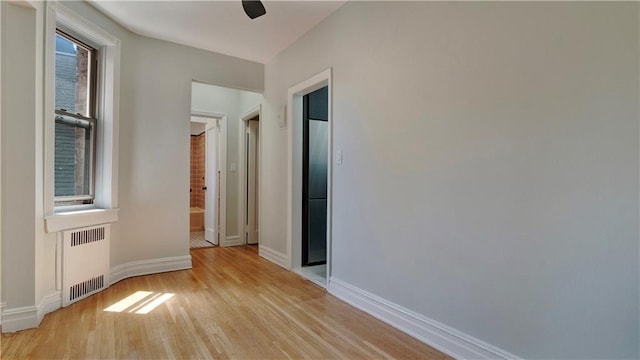 1560 E 18th St Unit 3D, Brooklyn, NY 11230 - empty room featuring radiator heating unit and light wood-type flooring