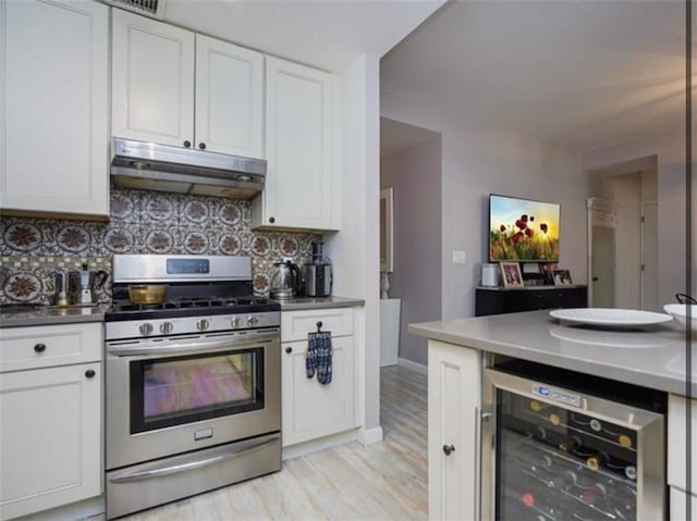 100 Oceana Dr W Unit 4J, Brooklyn, NY 11235 - kitchen featuring stainless steel range with gas cooktop, under cabinet range hood, beverage cooler, and white cabinetry
