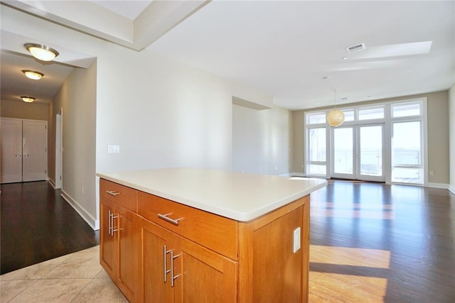 90 Bay Street Lndg Unit 4B, Staten Island, NY 10301 - kitchen featuring light wood-style floors, light countertops, brown cabinetry, a center island, and open floor plan