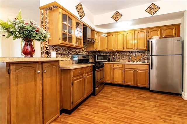 1717 Avenue N Unit 3C, Brooklyn, NY 11230 - kitchen featuring appliances with stainless steel finishes, wall chimney exhaust hood, light countertops, and light wood finished floors