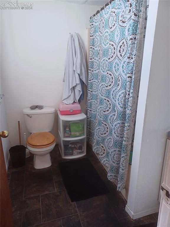 bathroom featuring tile floors and toilet