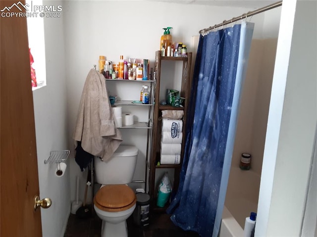 bathroom with shower / tub combo, tile flooring, and toilet