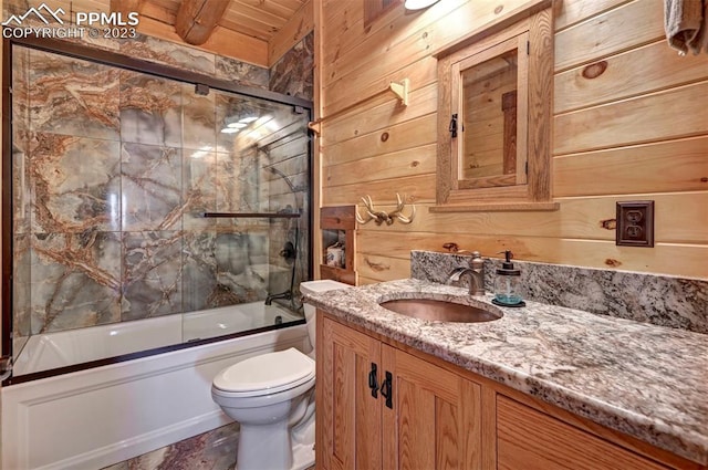 full bathroom featuring wood walls, vanity, wooden ceiling, bath / shower combo with glass door, and toilet