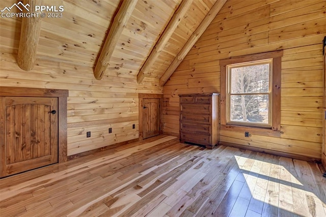 additional living space featuring wood walls, lofted ceiling with beams, wooden ceiling, and light wood-type flooring