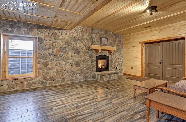 living area featuring wooden ceiling, a fireplace, hardwood / wood-style flooring, and wooden walls