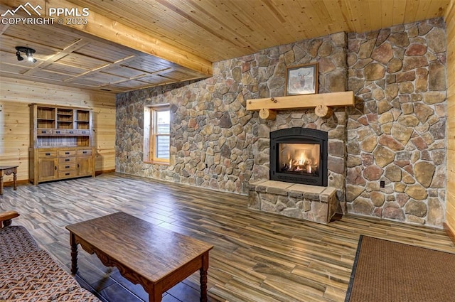 unfurnished living room featuring wooden walls, a stone fireplace, hardwood / wood-style floors, and wooden ceiling