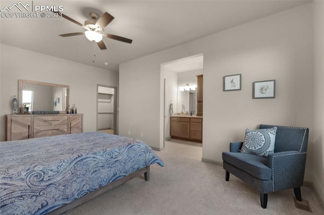 carpeted bedroom with ensuite bath and ceiling fan