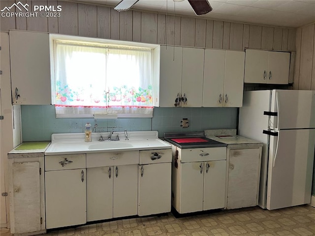 kitchen with ceiling fan, sink, white refrigerator, and white cabinets