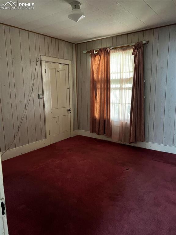 spare room with dark colored carpet