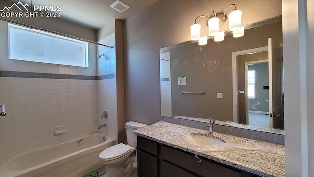 full bathroom featuring tiled shower / bath, a wealth of natural light, toilet, and vanity