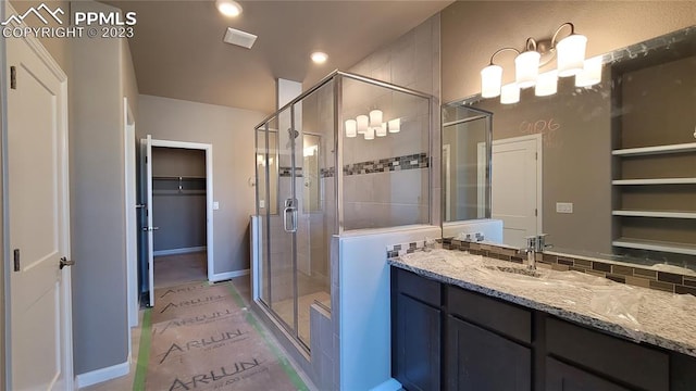 bathroom featuring walk in shower and large vanity