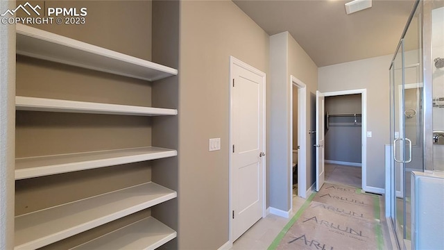 walk in closet featuring light tile floors