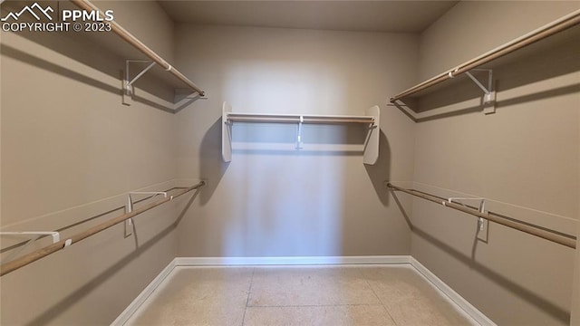 walk in closet with tile floors