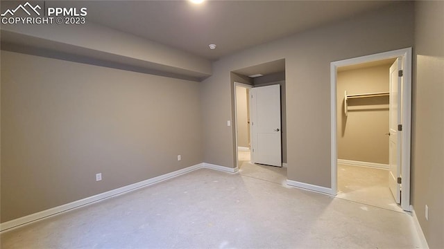 unfurnished bedroom with a closet and a spacious closet