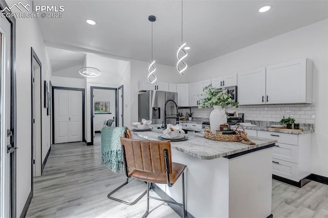 kitchen with white cabinetry, pendant lighting, an island with sink, and stainless steel appliances