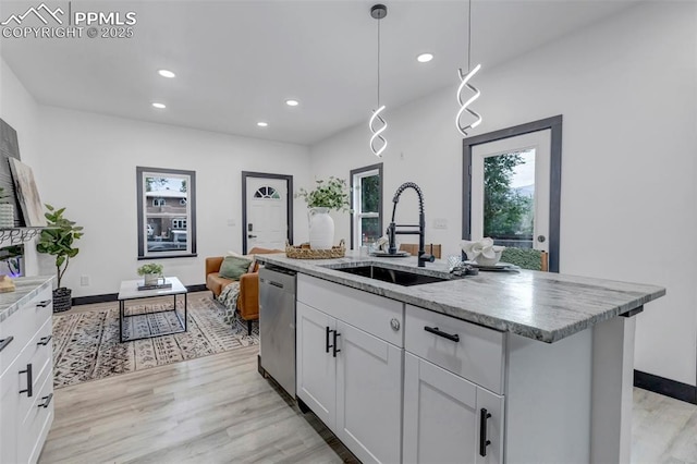 kitchen with white cabinets, dishwasher, sink, and a kitchen island with sink