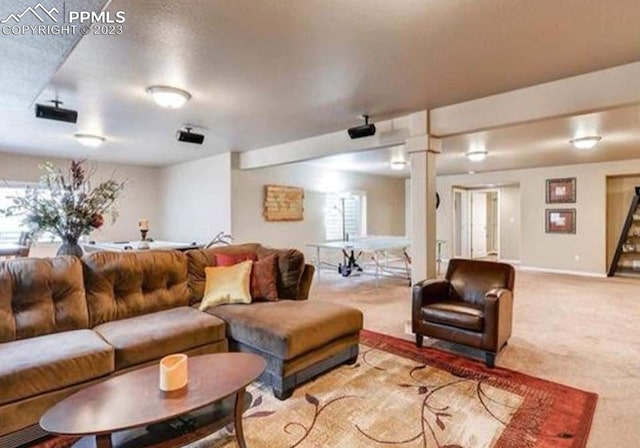 carpeted living room with decorative columns