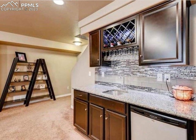 bar with dishwasher, decorative backsplash, sink, light stone counters, and light colored carpet