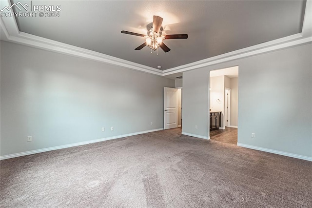 unfurnished bedroom featuring ceiling fan, a raised ceiling, carpet, and ensuite bathroom