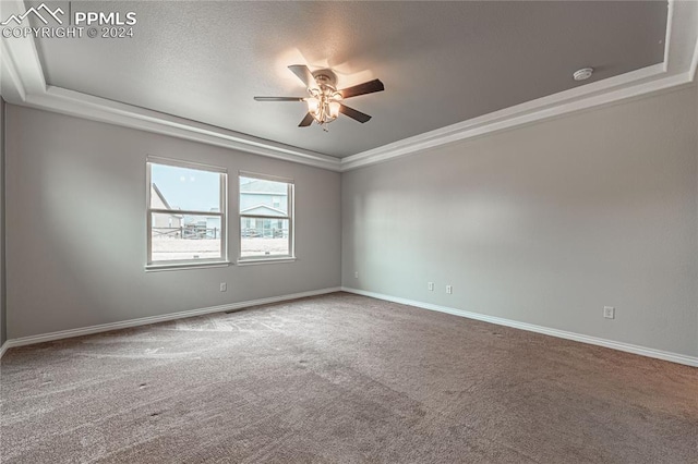 unfurnished room featuring ceiling fan, carpet flooring, a tray ceiling, and ornamental molding