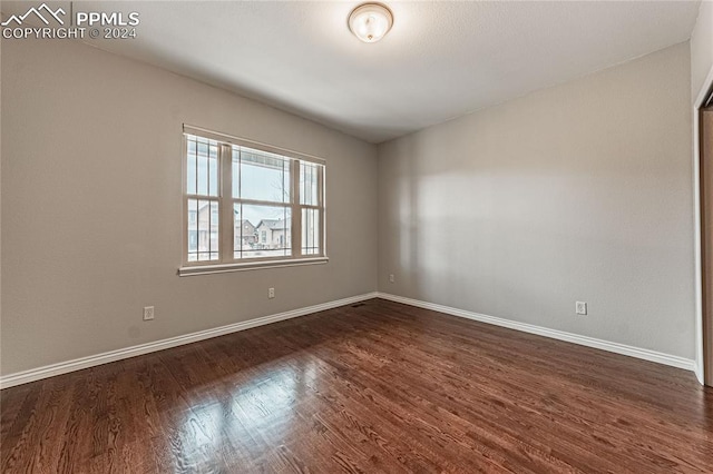 empty room with dark hardwood / wood-style flooring